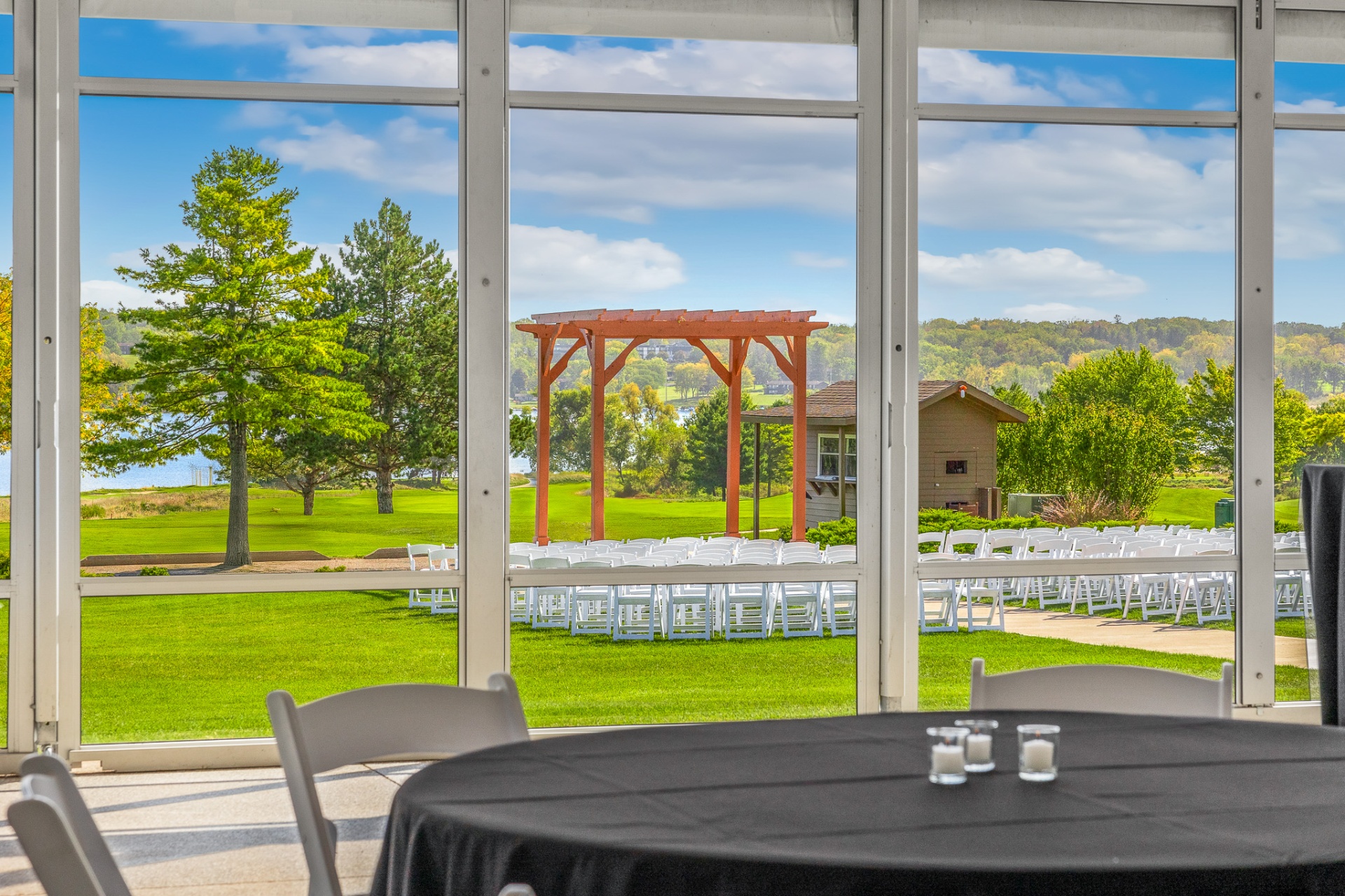 View of outdoor ceremony site and pergola through tent windows