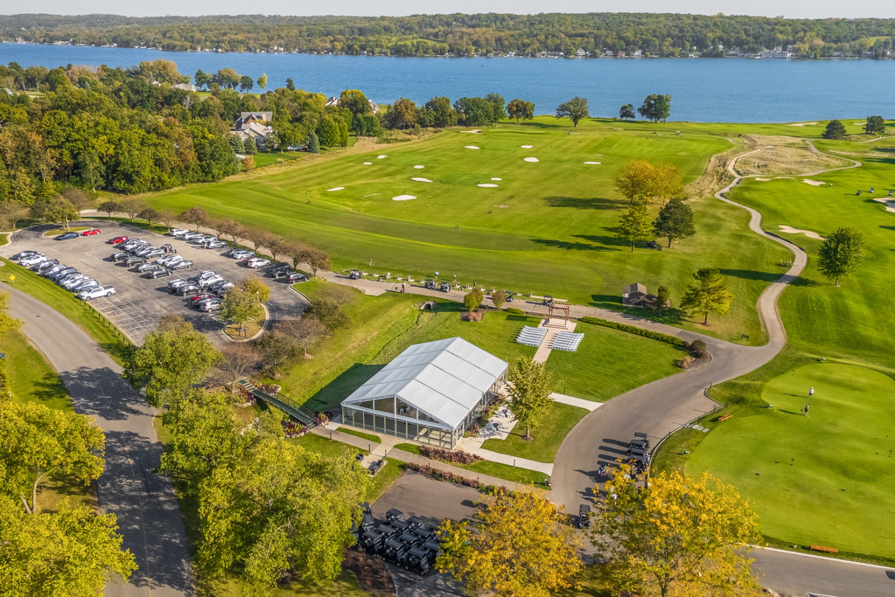 Aerial view of the white event tent beside the golf course and Lake Como