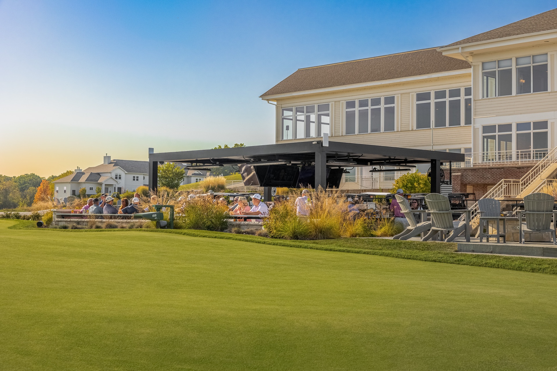 Outdoor patio bar and lounge area beside the clubhouse at sunset