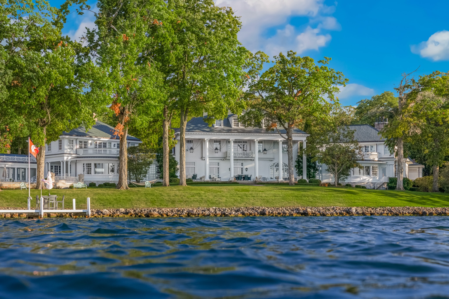 Stately white lakefront mansion framed by oak trees on the shores of Lake Como