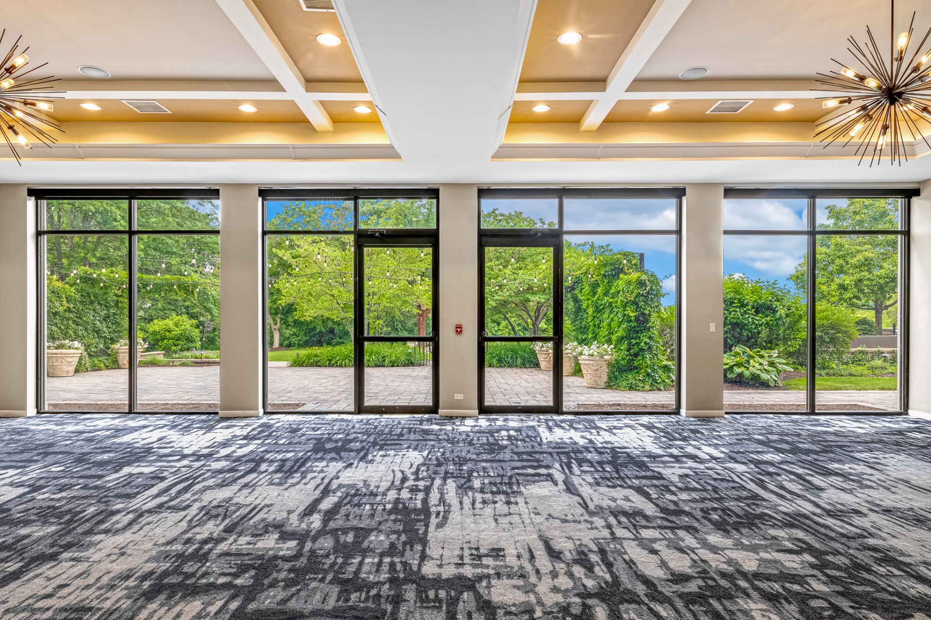 Event space with floor-to-ceiling windows opening to the patio